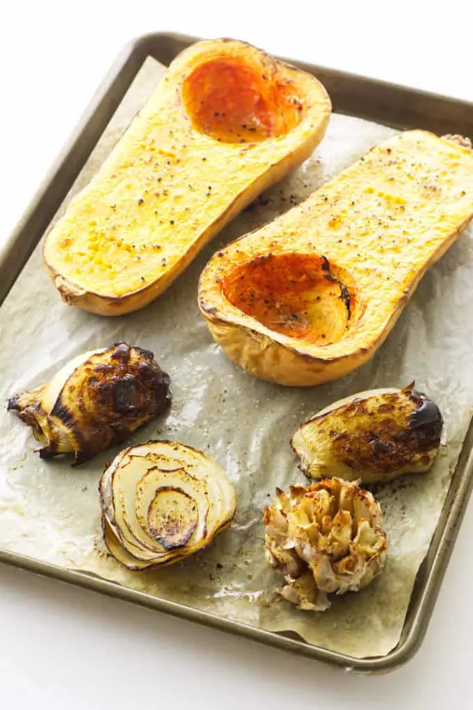 Baking sheet with roasted butternut squash, onions and garlic