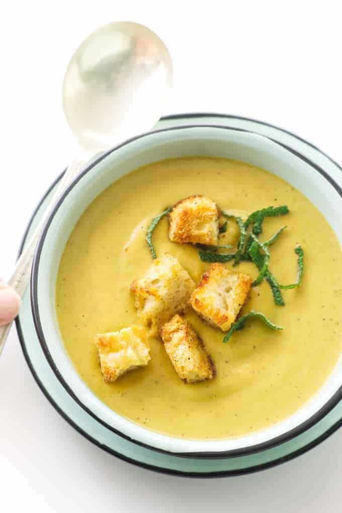 Overhead view of Butternut Sage soup with croutons and fresh sage garnish