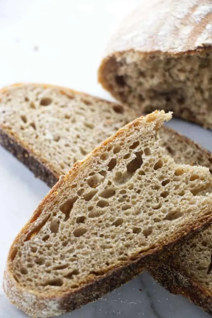 A slice of sourdough bread showing the inside.