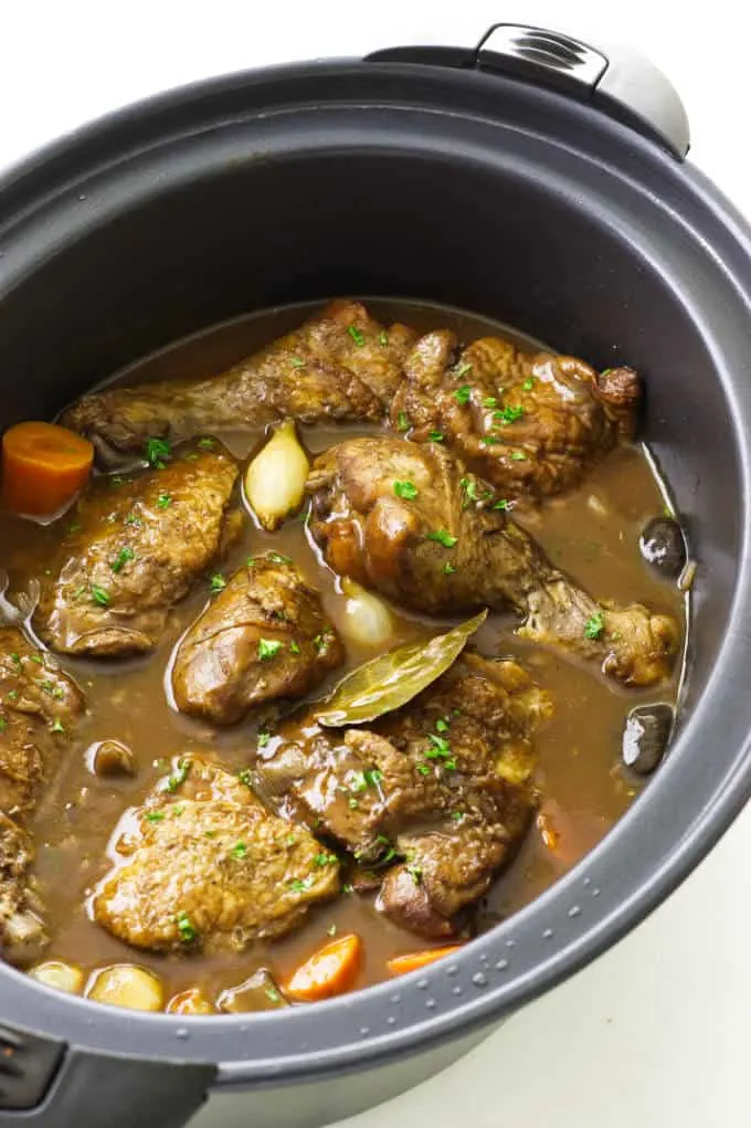 Coq au Vin in an oval slow cooker.