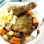 Coq au Vin in a bowl with noodles.