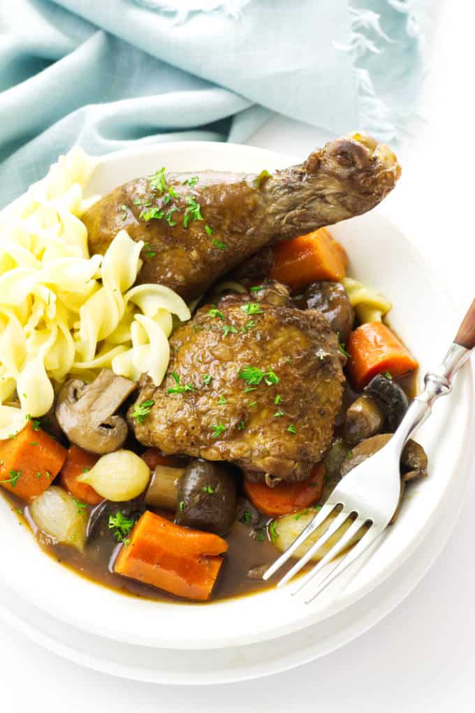 Coq au Vin in a bowl with noodles.