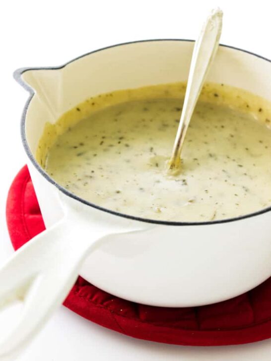 Saucepan with homemade condensed cream of mushroom soup, sitting on a red mat.
