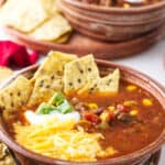 A bowl of taco soup with toppings.