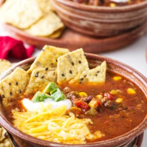 A bowl of taco soup with toppings.