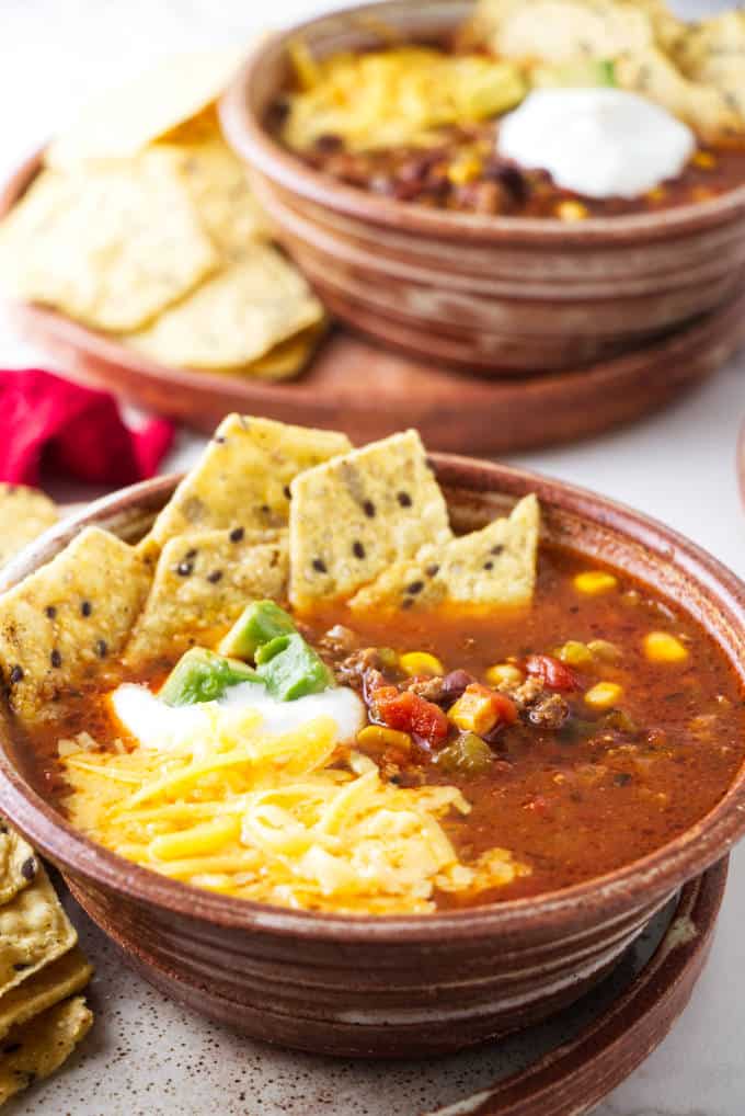 A bowl of taco soup with toppings.