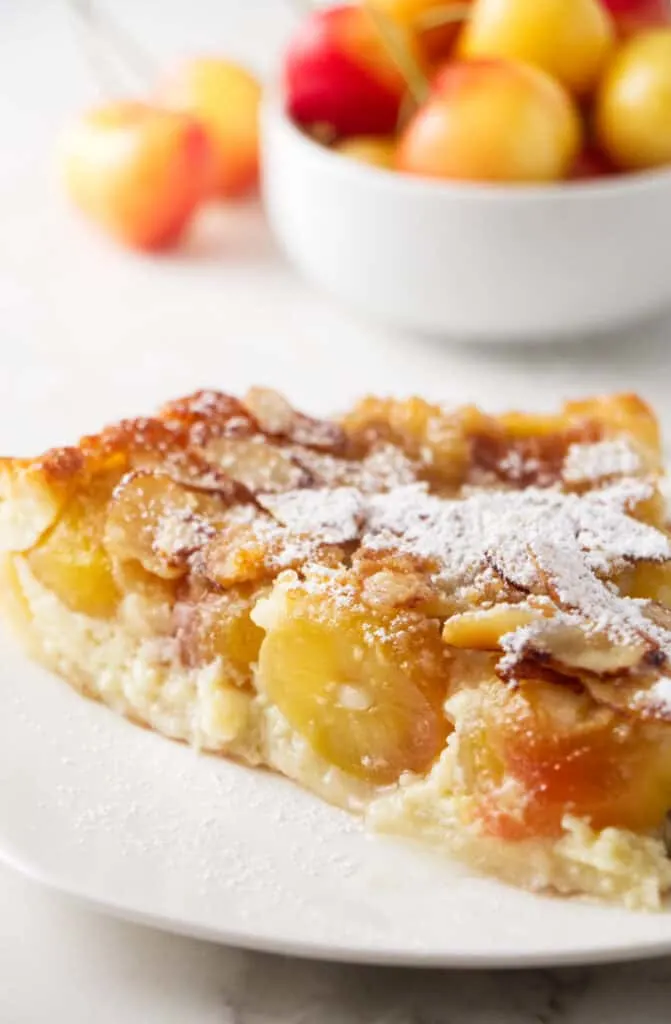 A slice of cherry clafoutis with rainier cherries.