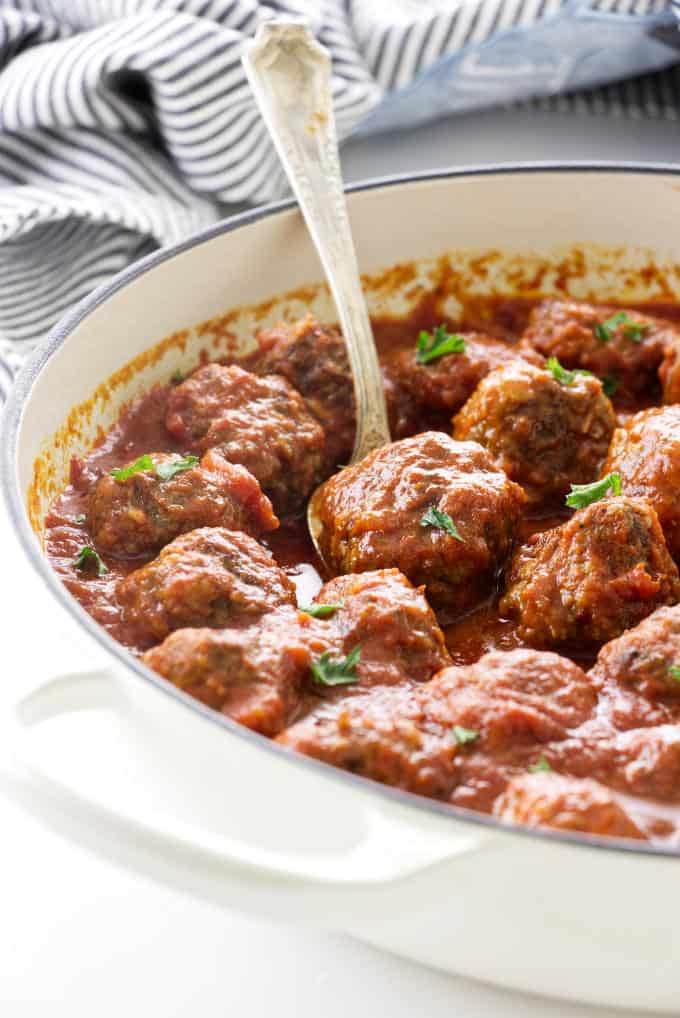 Beef and sausage meatballs in a skillet.