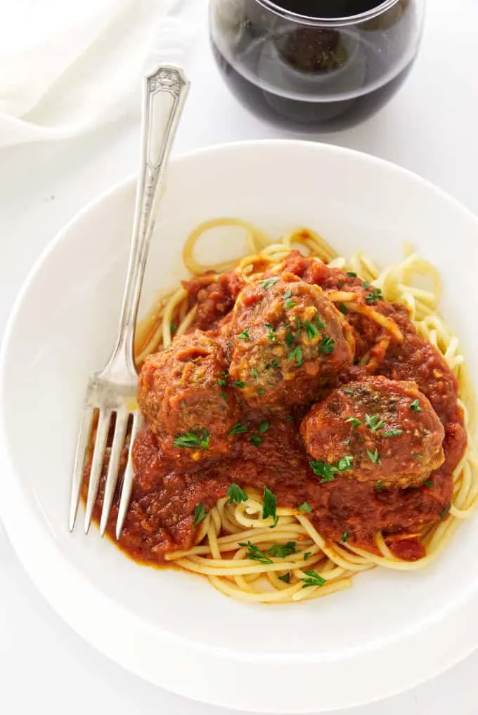 A pasta bowl with pasta and meatballs.