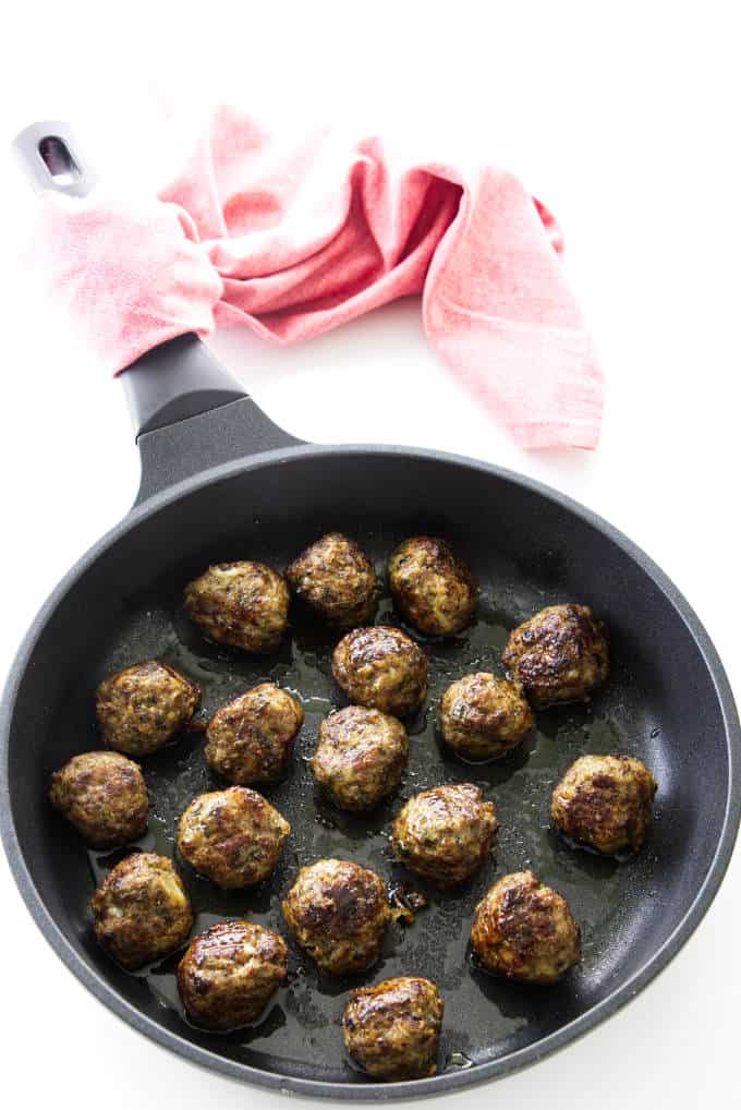 Overhead view of skillet with beef and sausage meatballs