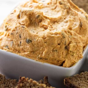 A close up photo of creamy Liptauer cheese spread and some rye bread.