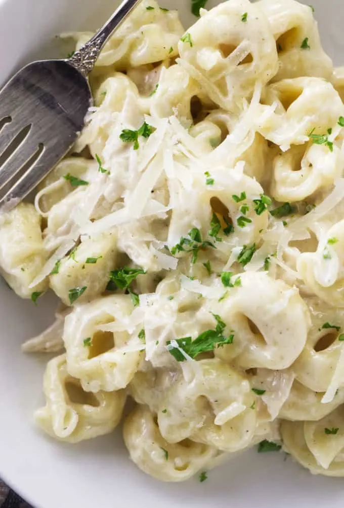 A bowl filled with Chicken Tortellini Alfredo pasta.