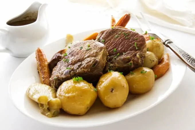 A serving platter of pork chop pot roast dinner.