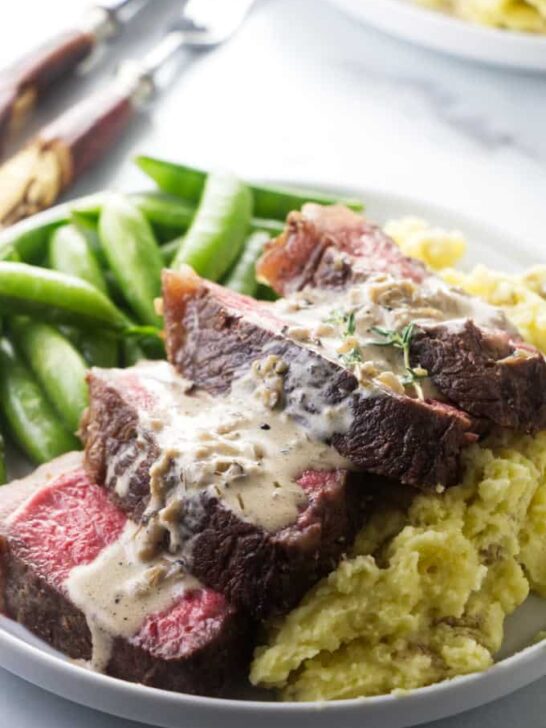 Bison ribeye steak on a bed of mashed potatoes.