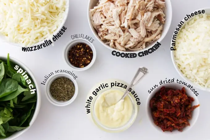 Ingredients used to make chicken spinach pizza with white garlic pizza sauce.