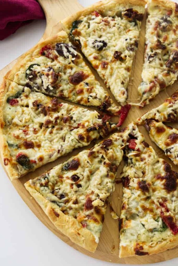 A freshly baked mushroom pizza sliced on a pizza peel.