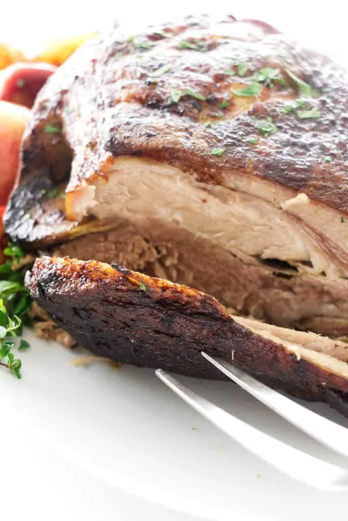 Slicing a pork roast on a platter.