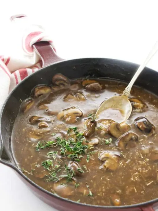 White wine mushroom sauce in a skillet with a spoon