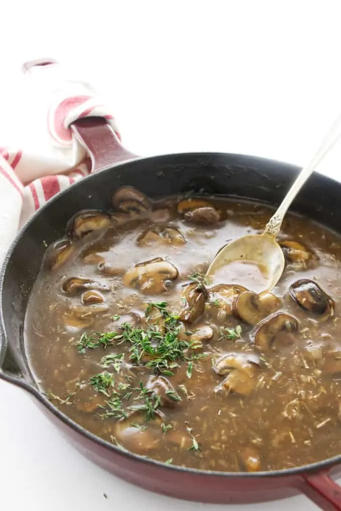 White wine mushroom sauce in a skillet with a spoon