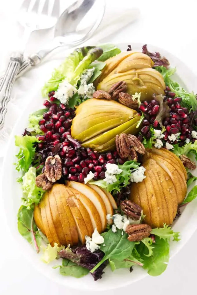 Pomegranate pear salad with blue cheese on a large serving platter.
