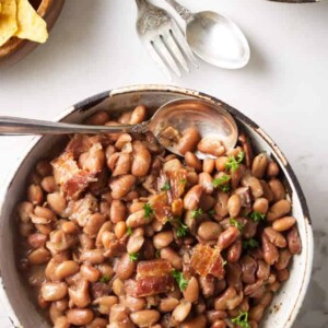 Two bowls of instant pot pinto beans with some corn chips.