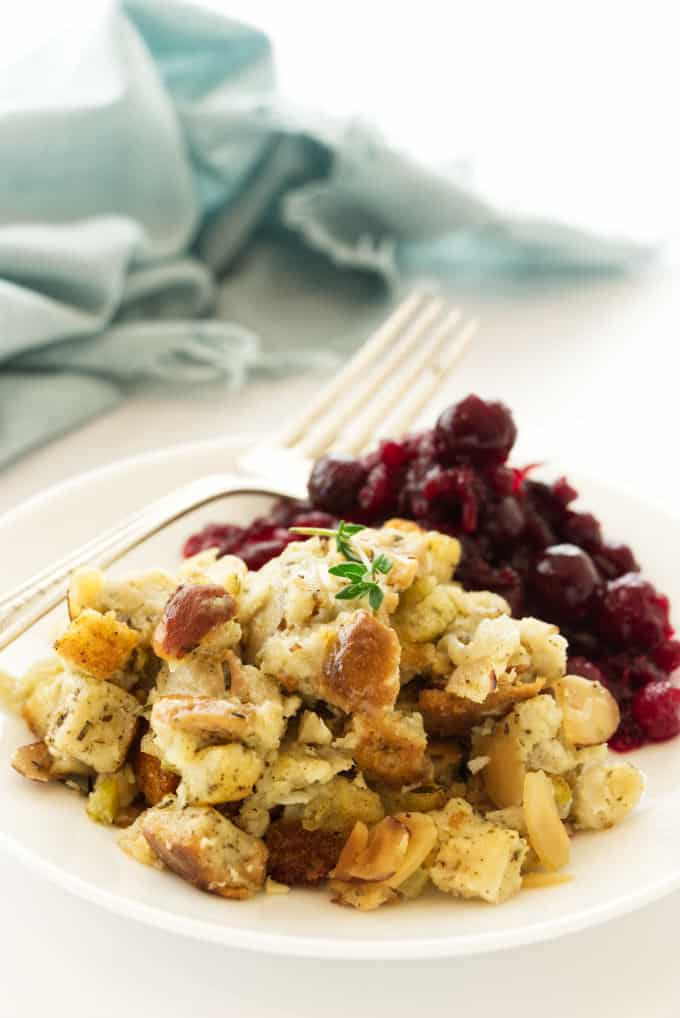 Mushroom stuffing on a plate with some cranberry sauce.