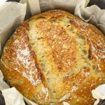 No-knead rosemary bread in a Dutch oven with parchment paper.