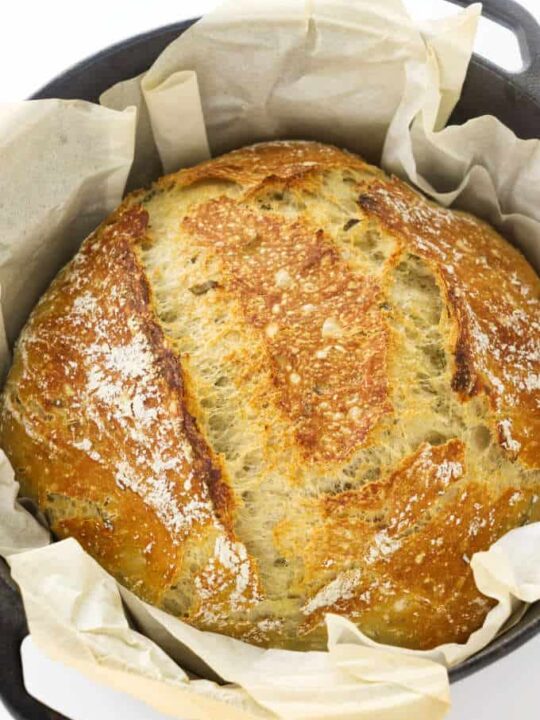 No-knead rosemary bread in a Dutch oven with parchment paper.