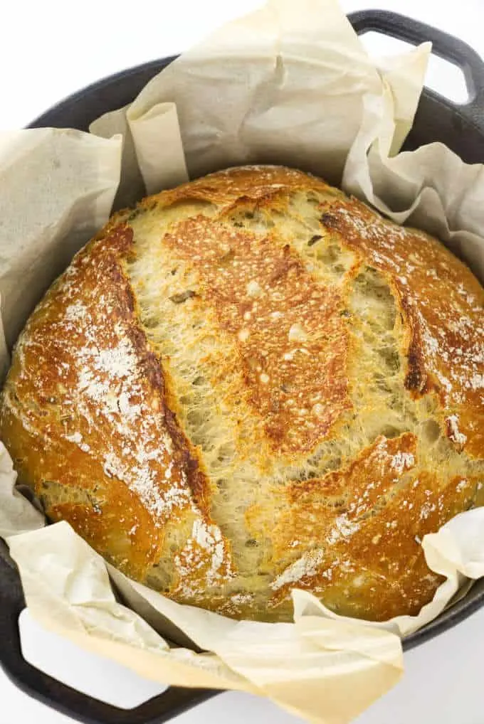 No-knead rosemary bread in a Dutch oven with parchment paper.