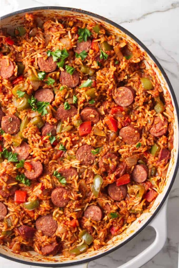 A large skillet filled with a sausage and rice one dish dinner.