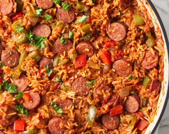 A large skillet filled with a sausage and rice one dish dinner.