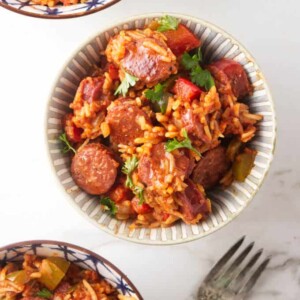 Three bowls of sausage and rice skillet dinner.