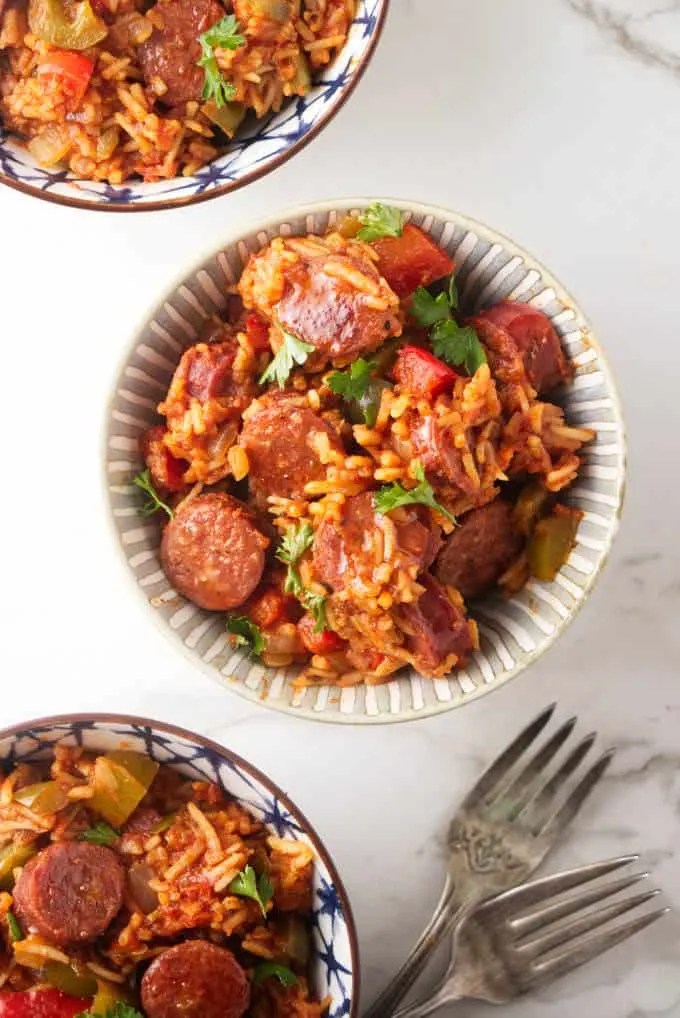 Three bowls of sausage and rice skillet dinner.