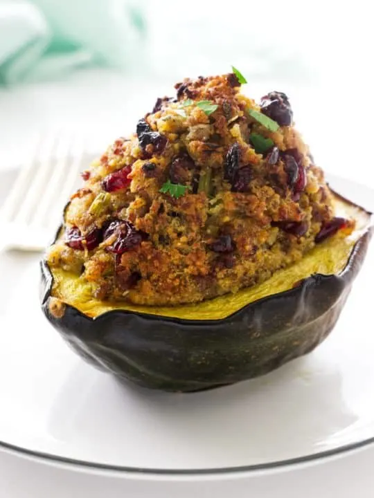 A sausage stuffed acorn squash with the stuffing piled high on the squash.