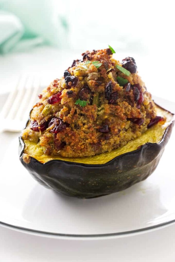 A sausage stuffed acorn squash with the stuffing piled high on the squash.