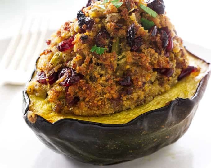 A sausage stuffed acorn squash with the stuffing piled high on the squash.