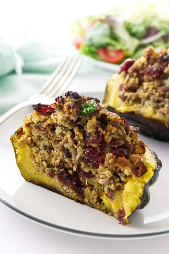 Sausage stuffed acorn squash sliced in half and showing the filling.