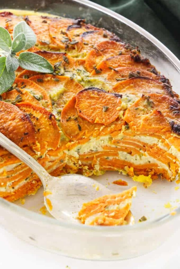 Scalloped sweet potato casserole in a casserole dish showing the layers of potato and cheese.