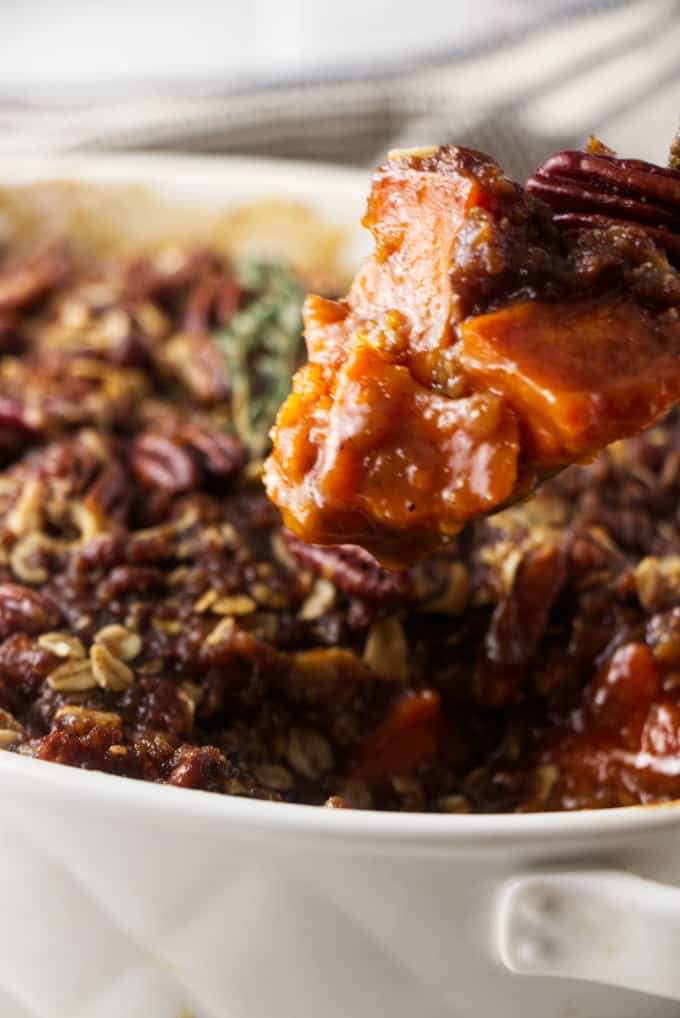 Close up of a bite of sweet potato casserole with pecan streusel on top.