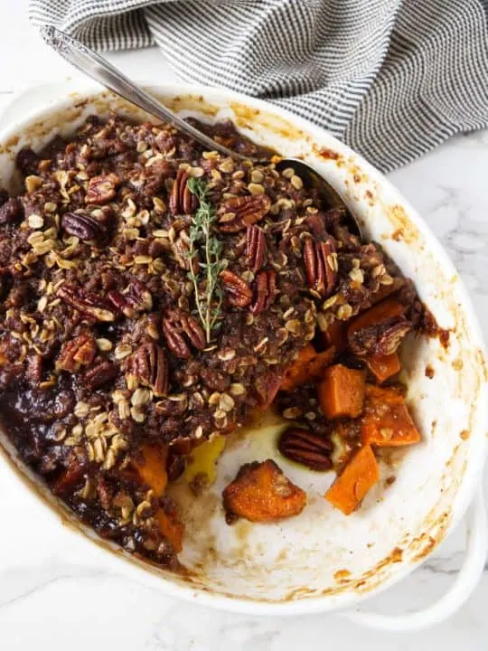 Sweet potato casserole in a white dish with pecan streusel on top.