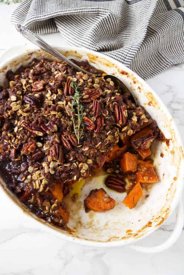 Sweet potato casserole in a white dish with pecan streusel on top.