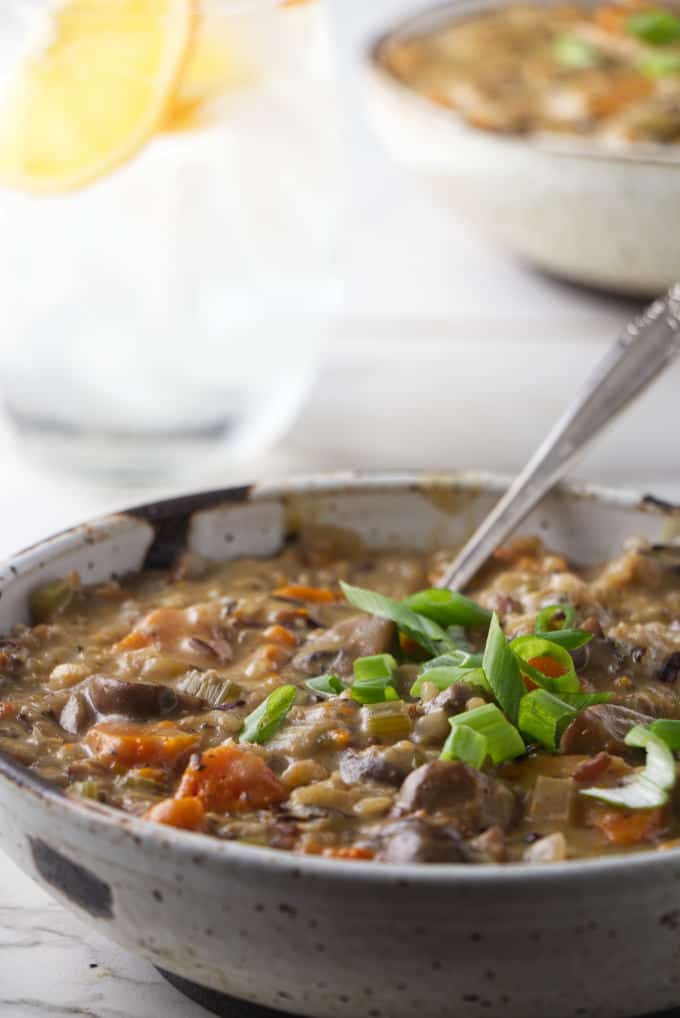 Wild rice and mushroom soup with a glass of water in the background.