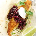 Fish taco with pomegranate salsa, jicama slaw and a lime wedge