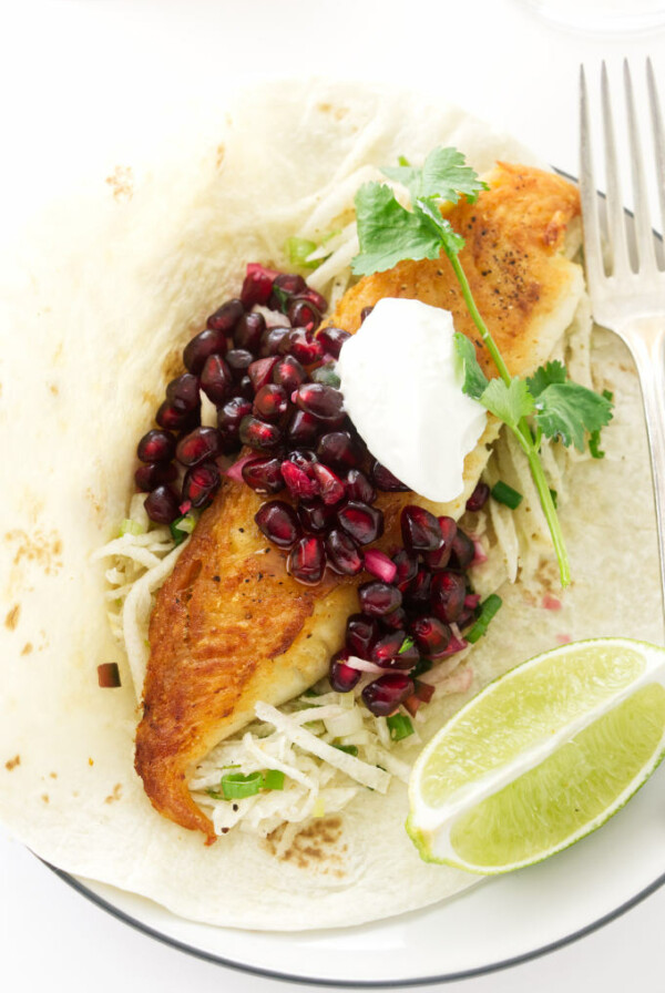 Fish taco with pomegranate salsa, jicama slaw and a lime wedge