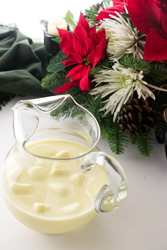 Pitcher of non-alcoholic eggnog with floating eggnog ice cubes