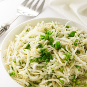 Bowl of Jicama Slaw, serving fork and napkin