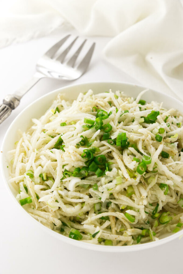 Bowl of Jicama Slaw, serving fork and napkin