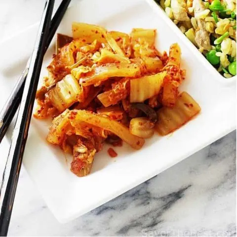A plate of kimchi with chopsticks and fried rice