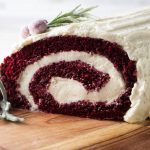 Red velvet cake roll showing the end of the roll with the swirl of cake and ermine frosting filling.