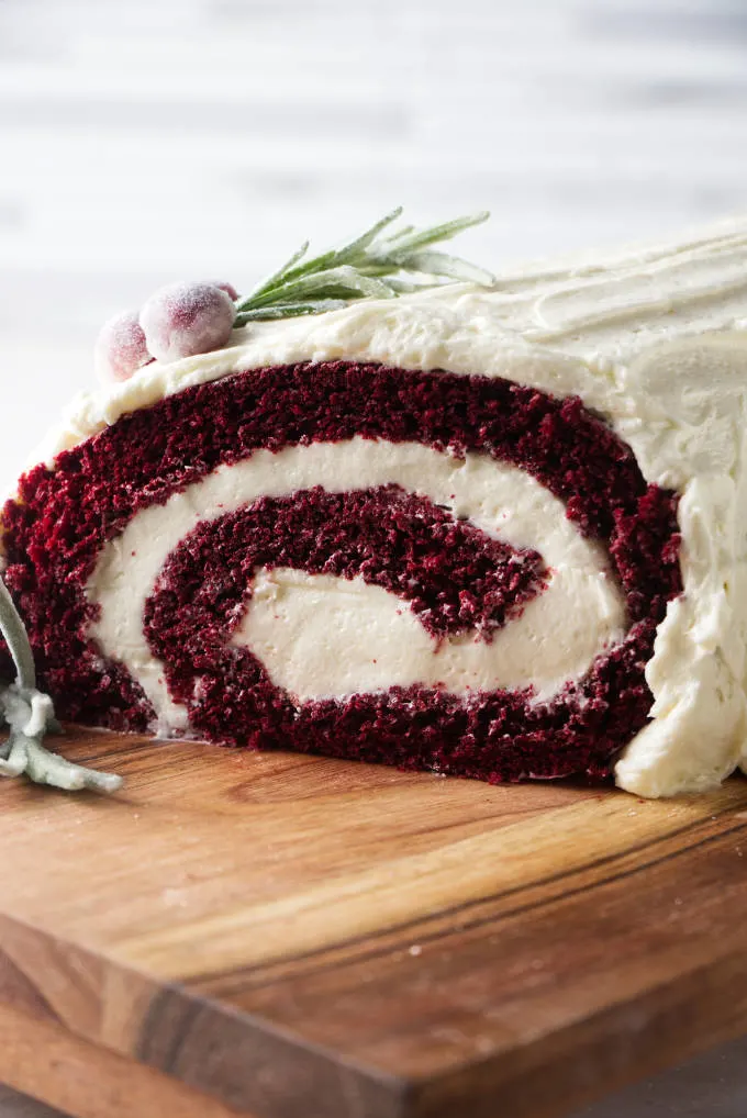 Red velvet cake roll showing the end of the roll with the swirl of cake and ermine frosting filling.